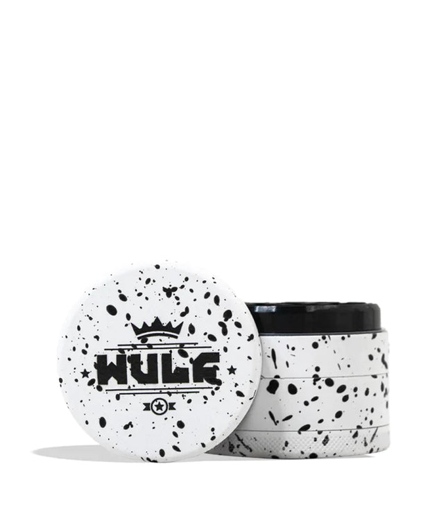 Front angled view of the Wulf 4-Piece 65mm Aerospace Aluminum Grinder in white with black splatter. Crafted from durable aerospace-grade metal, this large multi-chamber grinder effortlessly shreds dry botanicals to the perfect consistency for rolling or packing.