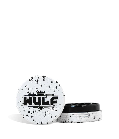Front angled view of the Wulf Mods 2-Piece 50mm Spatter Aluminum Grinder in white with black paint splatter. This ultra-compact, travel-friendly magnetic herb grinder features a streamlined two-piece design to quickly and efficiently shred your botanical blends without any extra bulk.