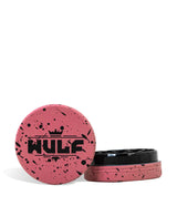 Front angled view of the Wulf Mods 2-Piece 65mm Spatter Aluminum Grinder in red with black paint splatter. This compact, travel-friendly magnetic herb grinder features a streamlined two-piece design to quickly and efficiently shred your botanical blends without added bulk.