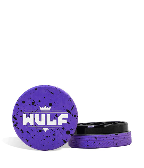 Front angled view of the Wulf Mods 2-Piece 65mm Spatter Aluminum Grinder in purple with black paint splatter. This compact, travel-friendly magnetic herb grinder features a streamlined two-piece design to quickly and efficiently shred your botanical blends without added bulk.