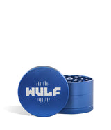 Front angled view of the Wulf Mods 4-Piece 65mm Aluminum Grinder in metallic blue with a white logo. Crafted from heavy-duty aluminum, this multi-chamber grinder effortlessly shreds dry botanicals to the perfect fluffy consistency for rolling or packing.